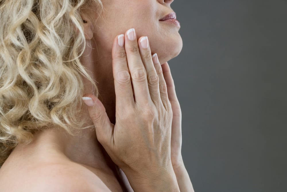 Woman applying face lotion.