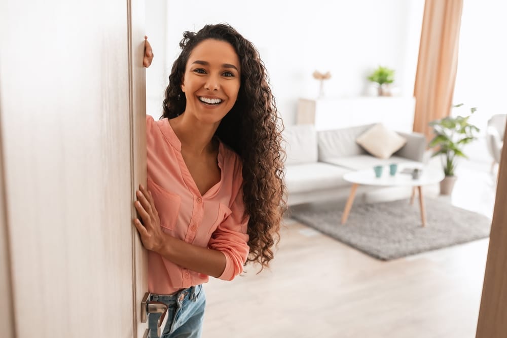 Woman closing the door to her apartment.