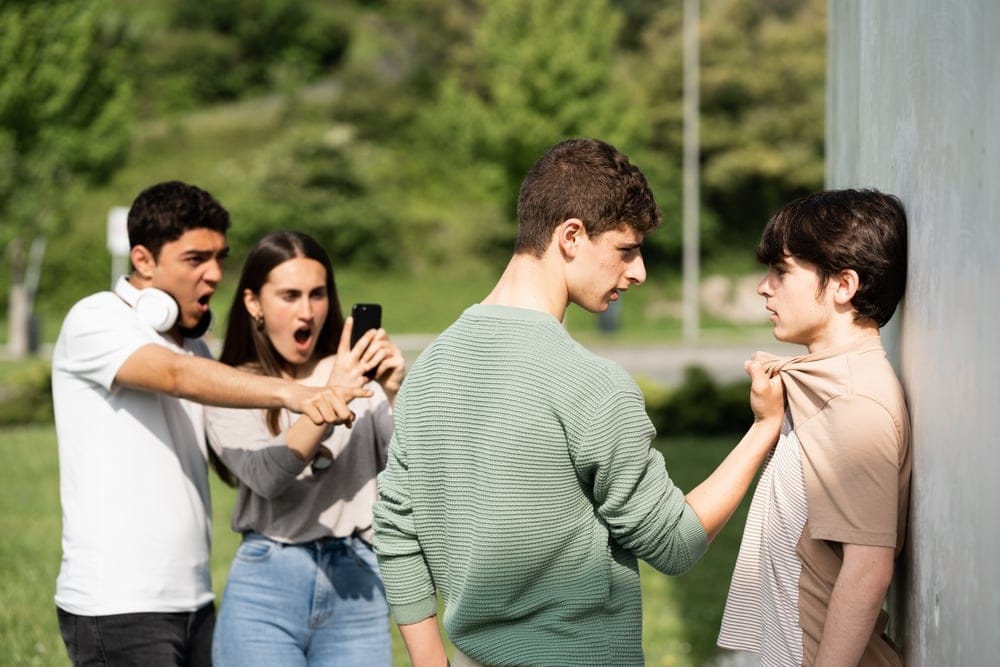 Teenager bullying another in the school yard.