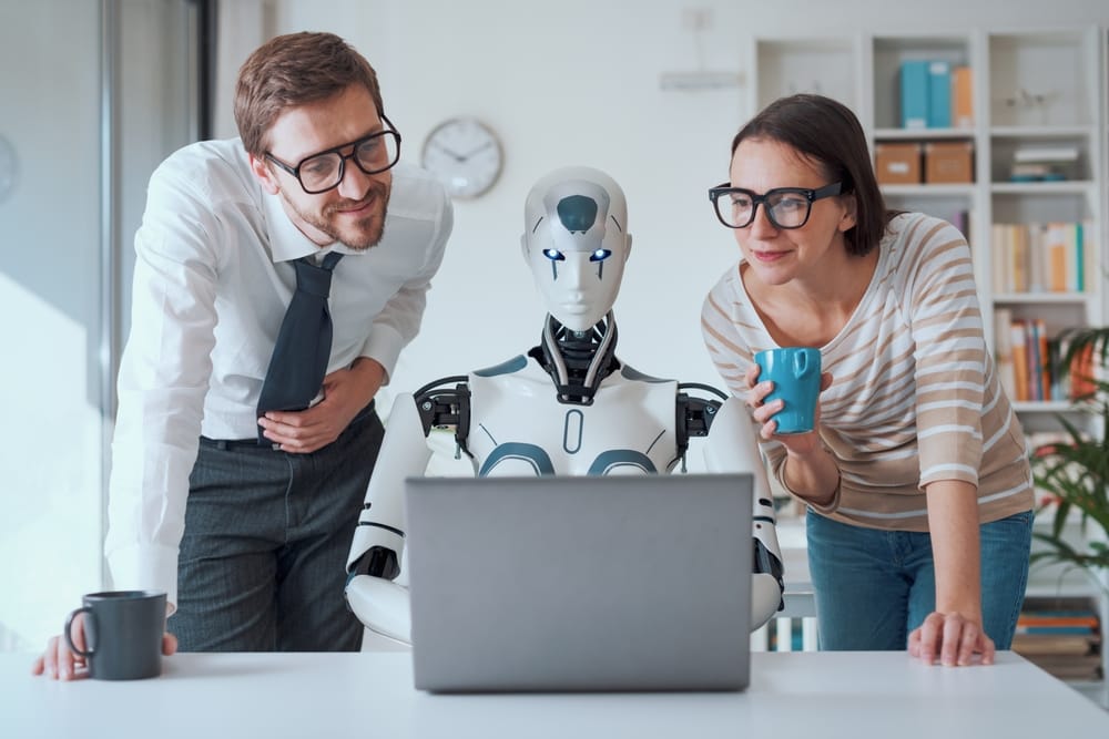 Business people leaning over a computer.