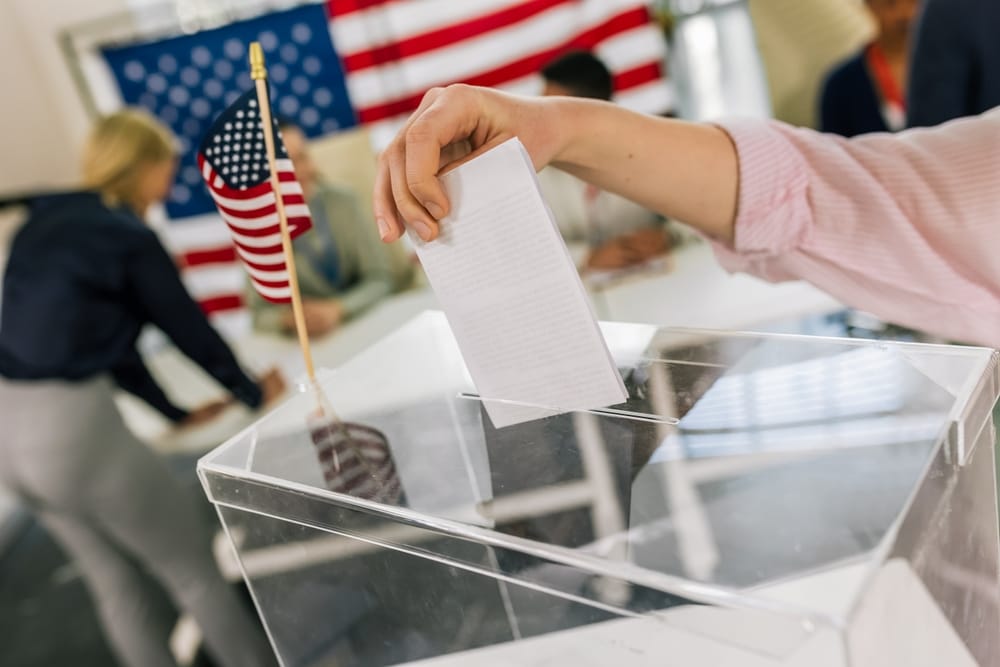 Woman placing her vote in a ballot box.