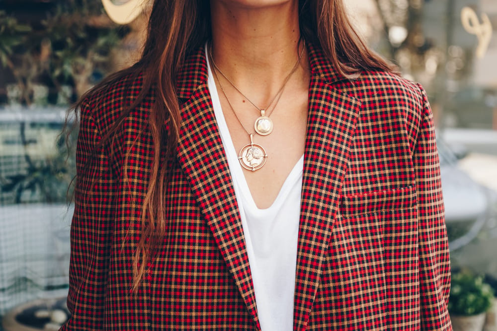 Woman in fashionable blazer and jewelry.