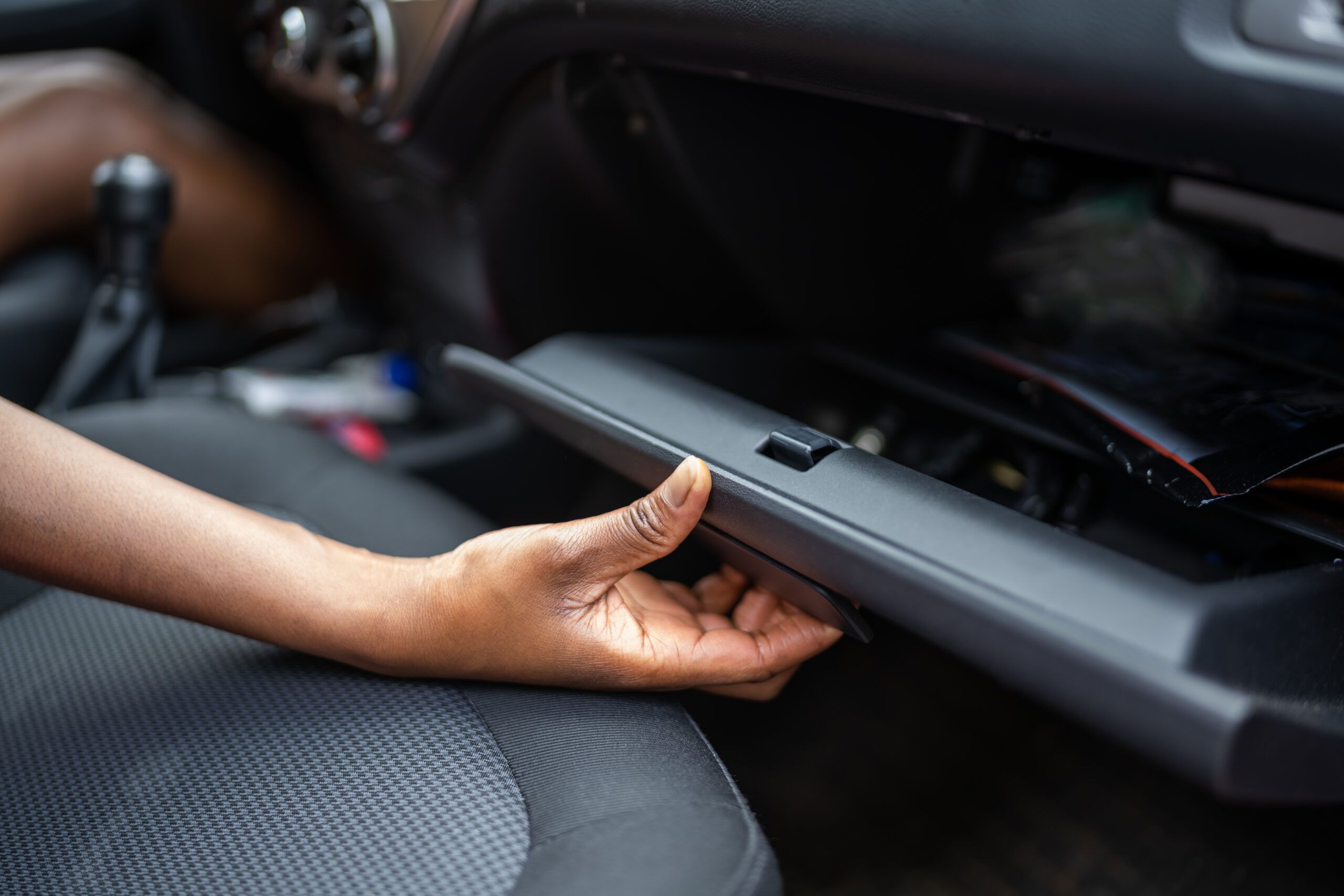 Woman reaching into her glove box.