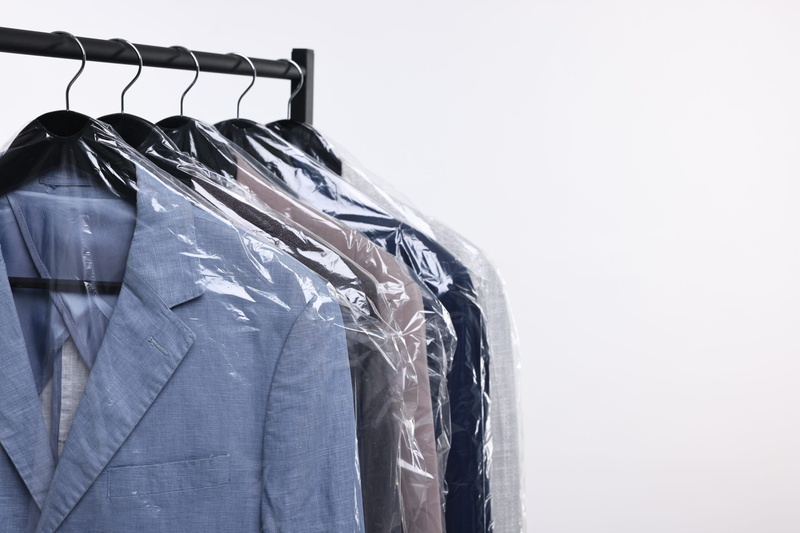 Dry cleaning bags hanging in the closet.