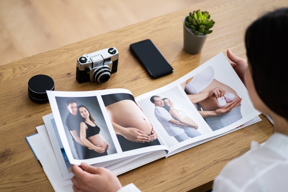 A woman looking at family photos and pictures from a pregnancy photoshoot