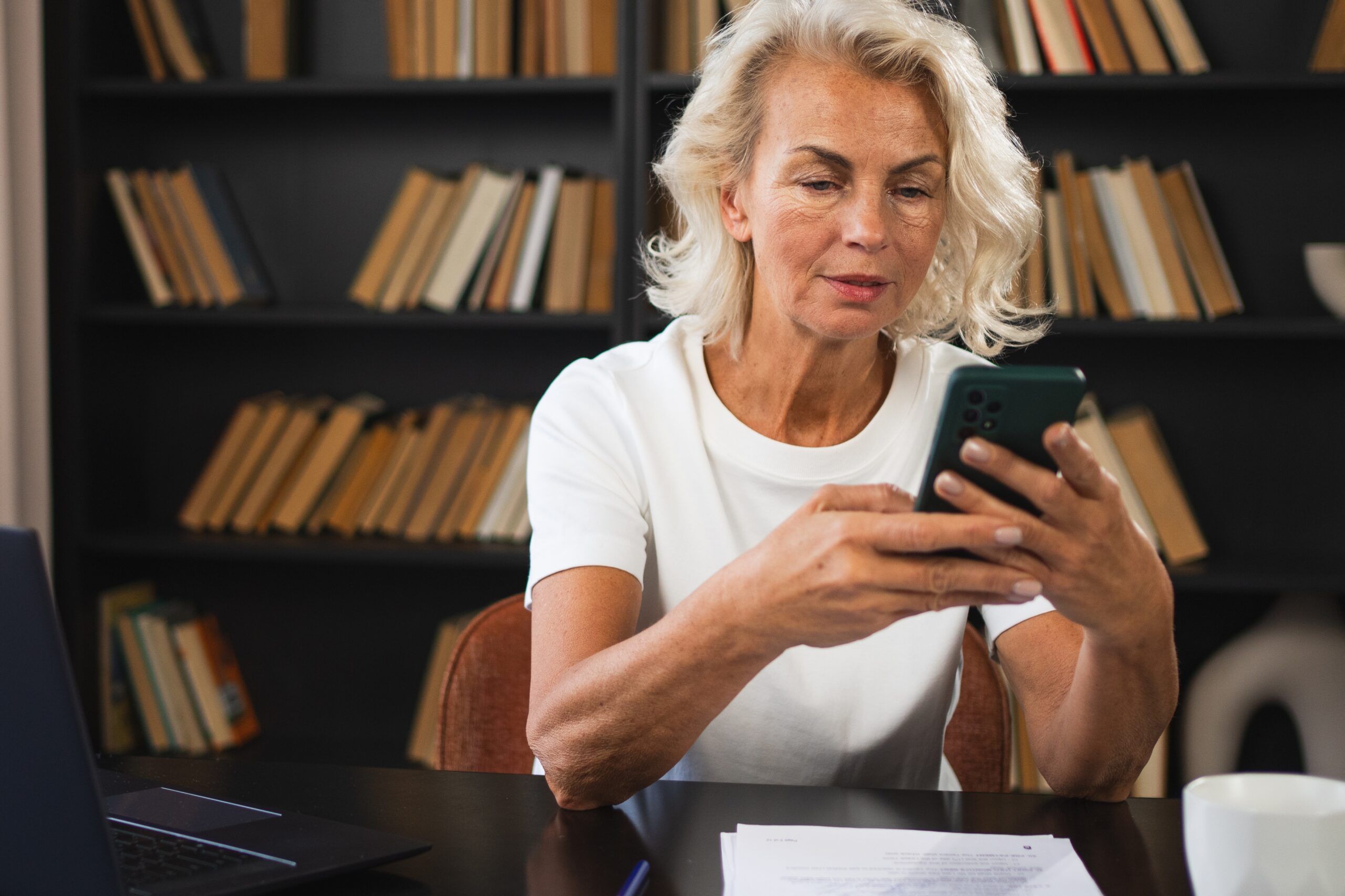 A mature career woman taking calls in her office.