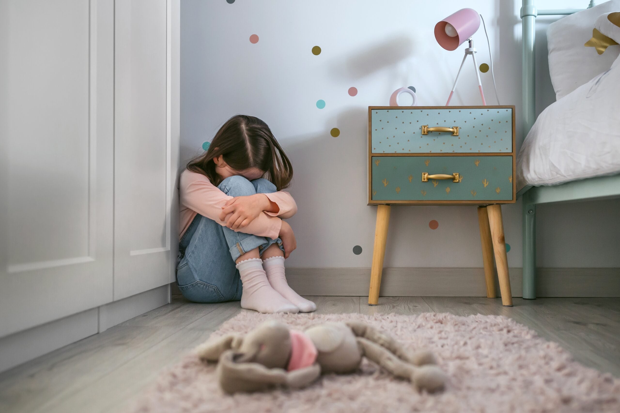A neglected little girl feeling isolated in her bedroom.