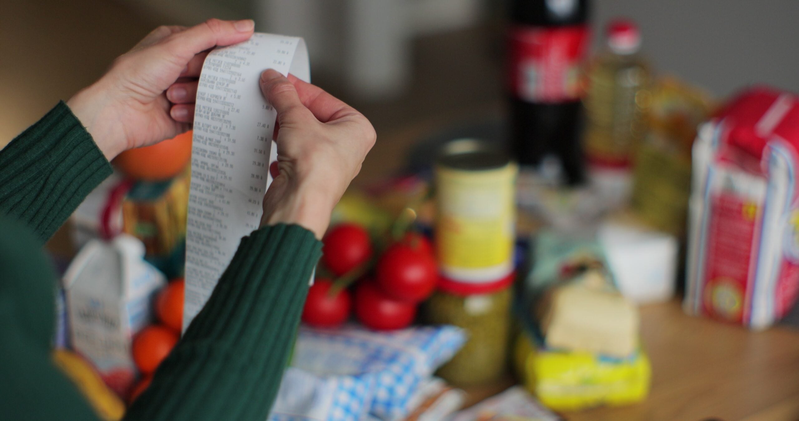A woman checking the receipt of her grocery bill.