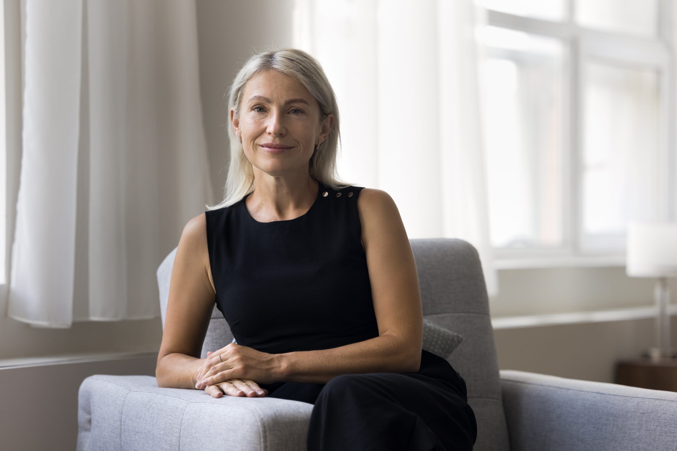 Confident woman sitting on couch.