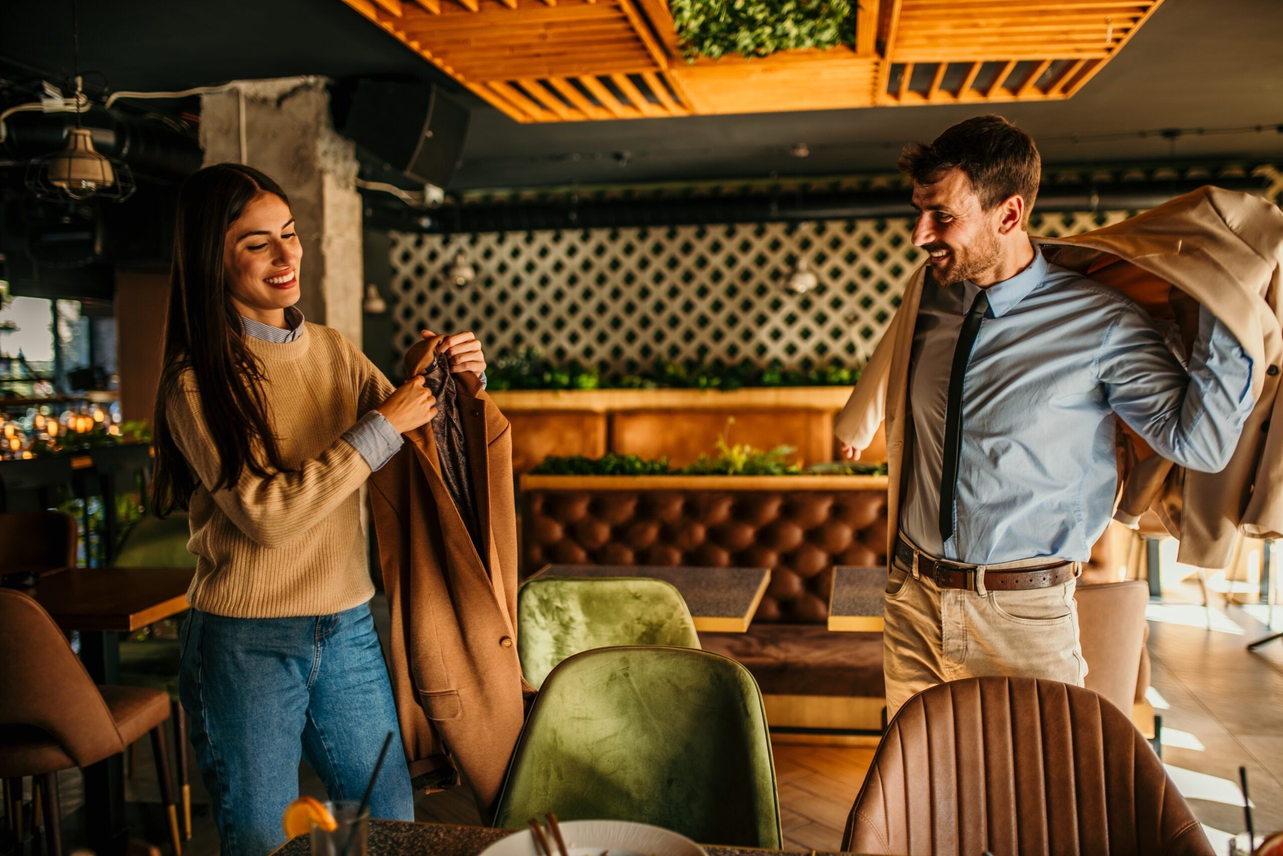 Two people preparing to leave after a meal in a restaurant.