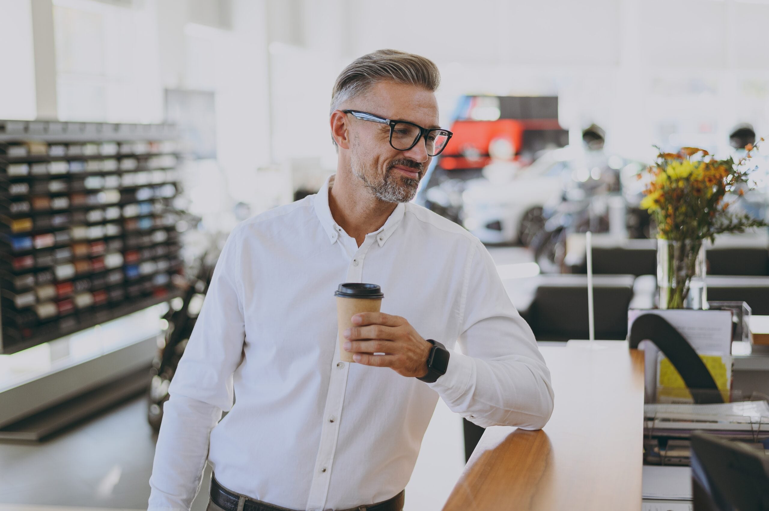 A confident businessman holding his takeout coffee.