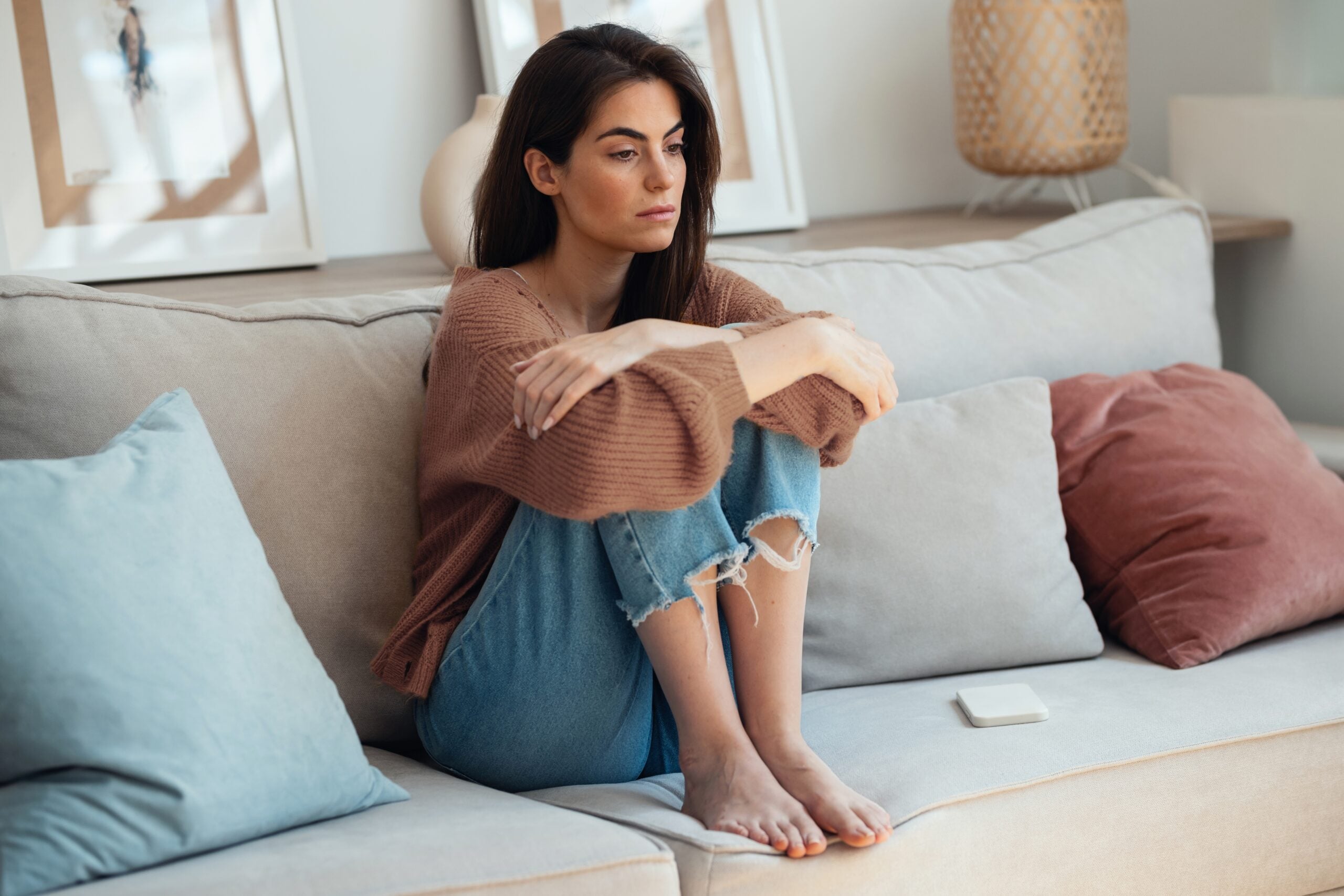 A woman sitting alone wishing she had a friend to call.