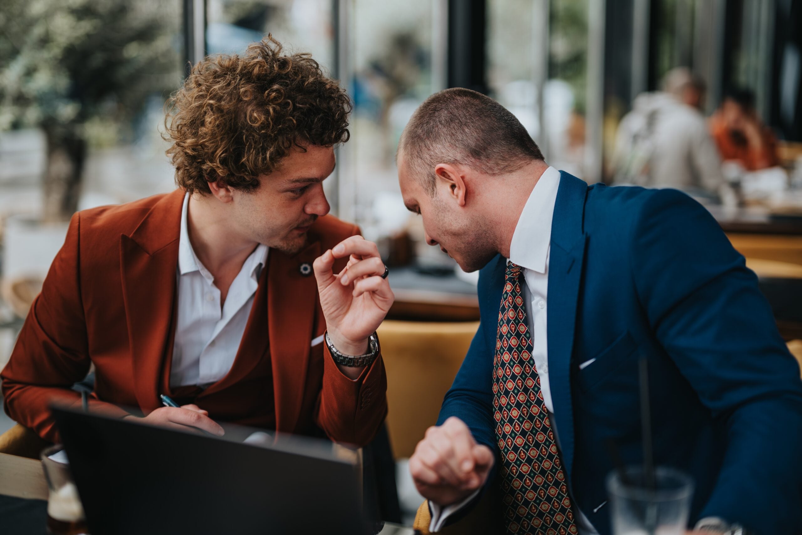 Two men in a serious conversation with one listening intently to the other.