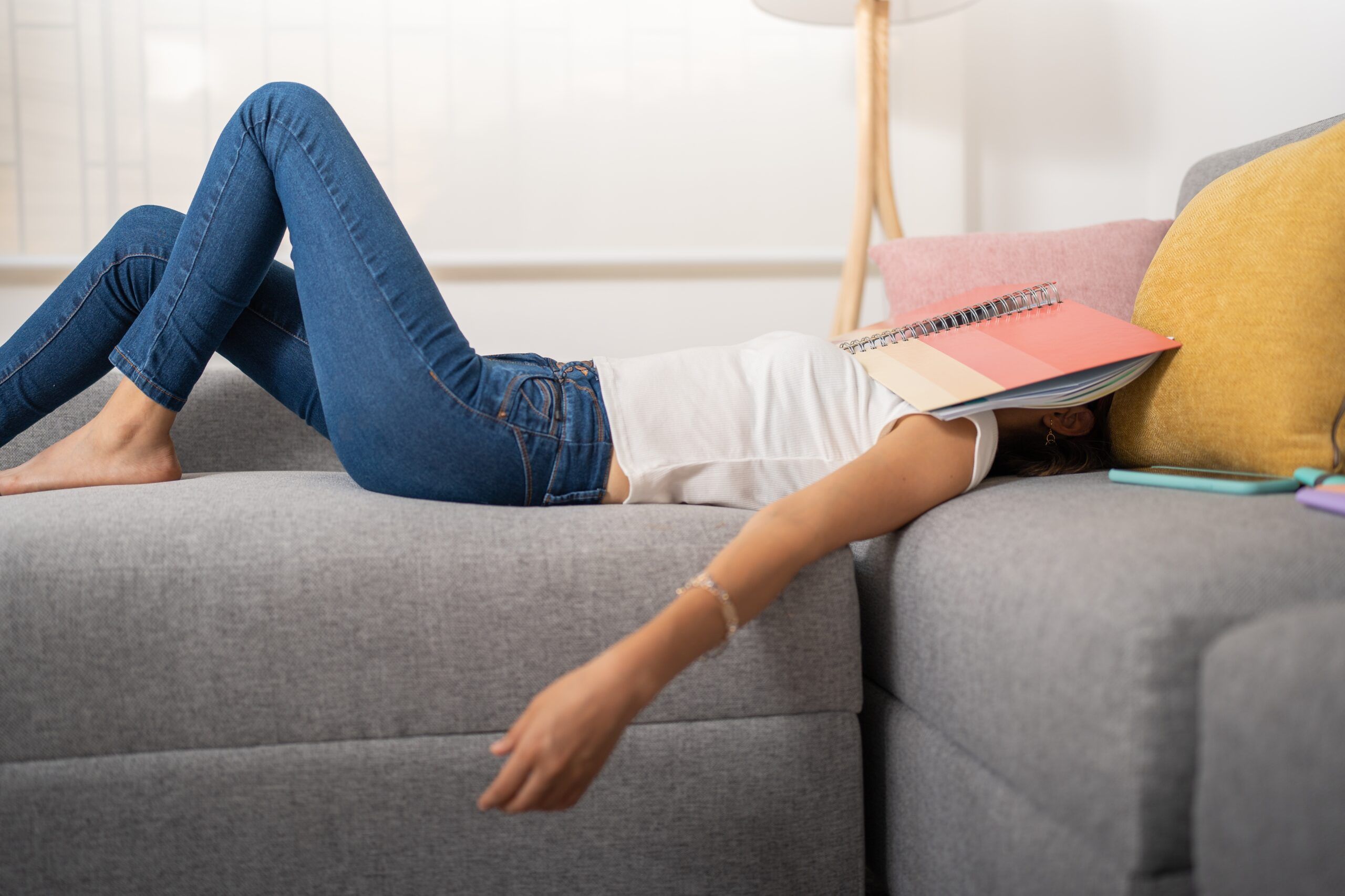 An exhausted woman feeling lazy on the couch.