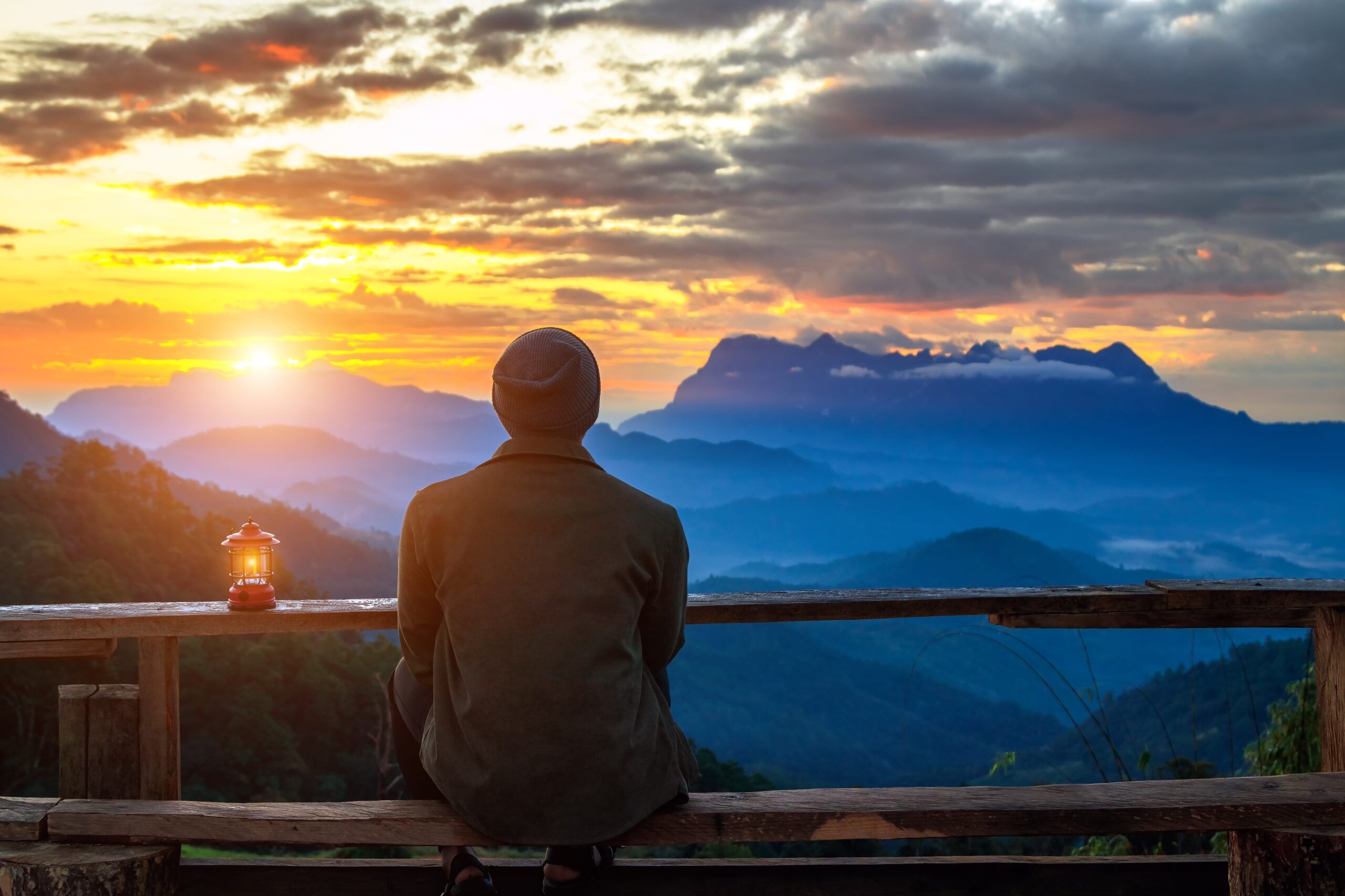 A man looking out over the mountains on a solo trip.