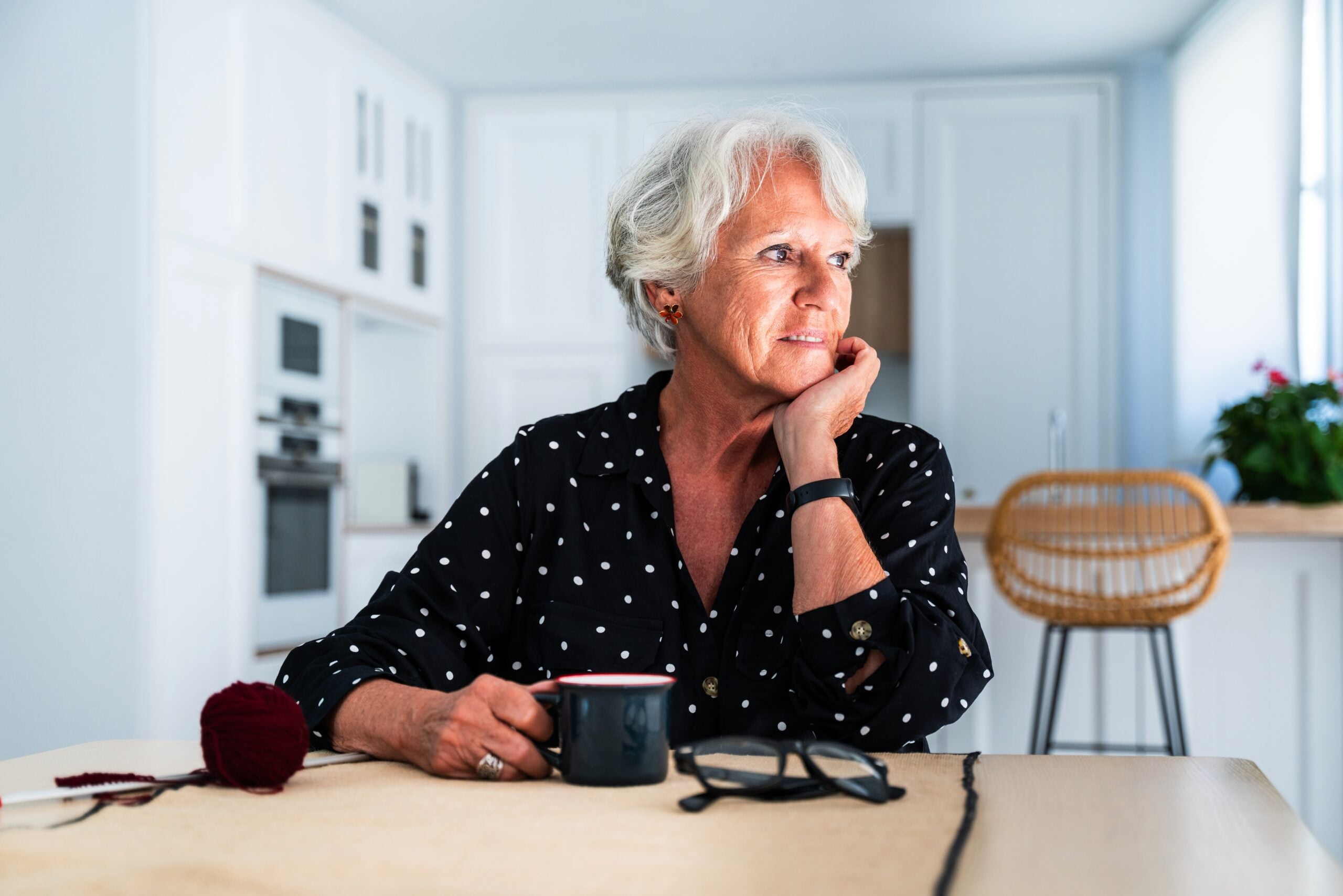 A content senior woman sitting at home with a cup of tea.