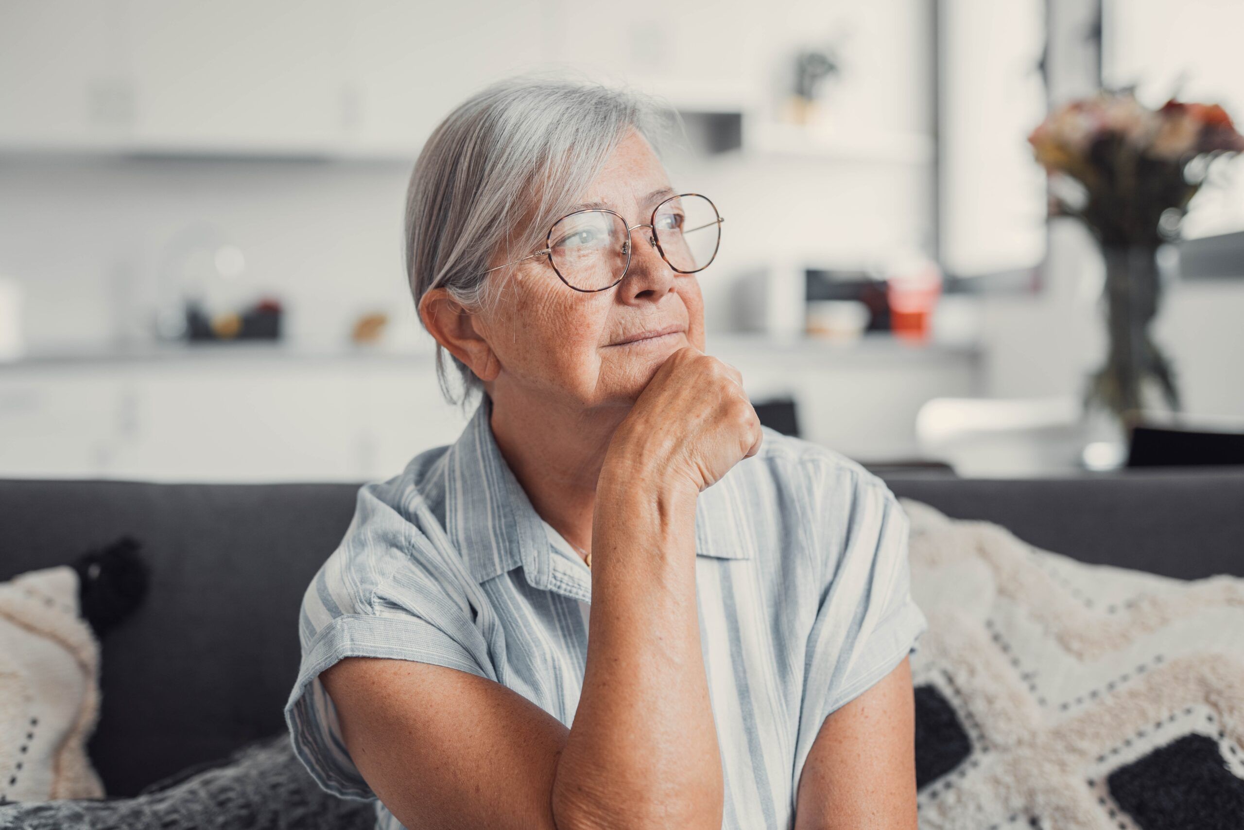 A senior woman sitting alone at home.