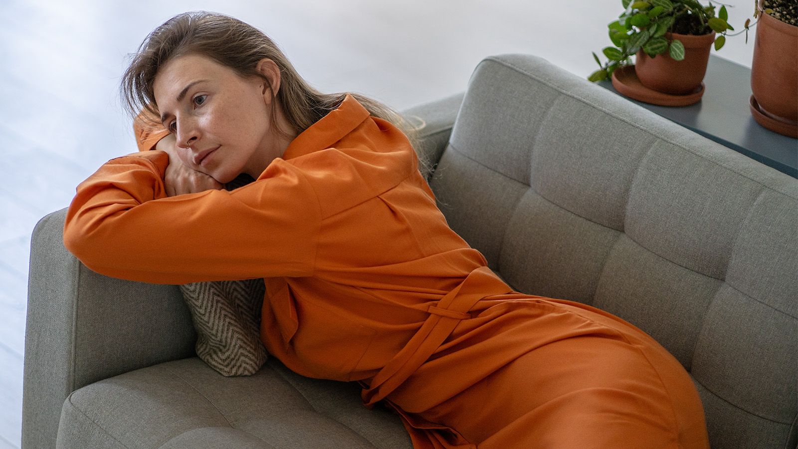 Woman lying on her coach, feeling alone and unseen.