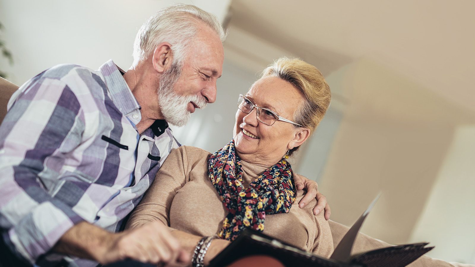 Two older people looking at cherished heirlooms and smiling