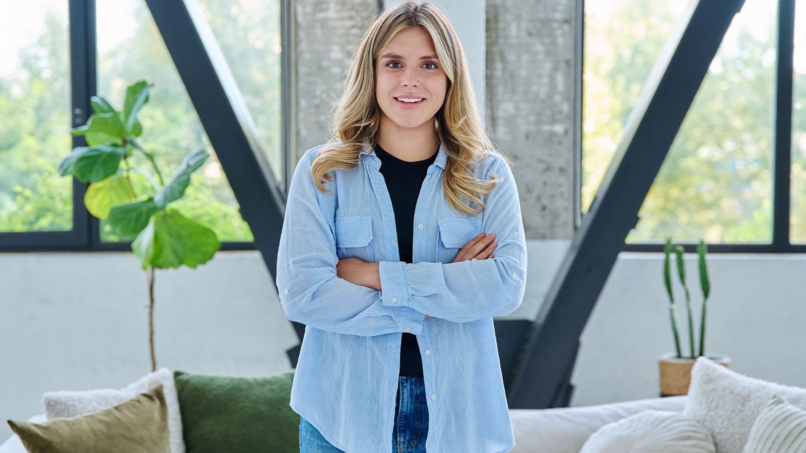 Portrait of young confident smiling woman in home interior-t