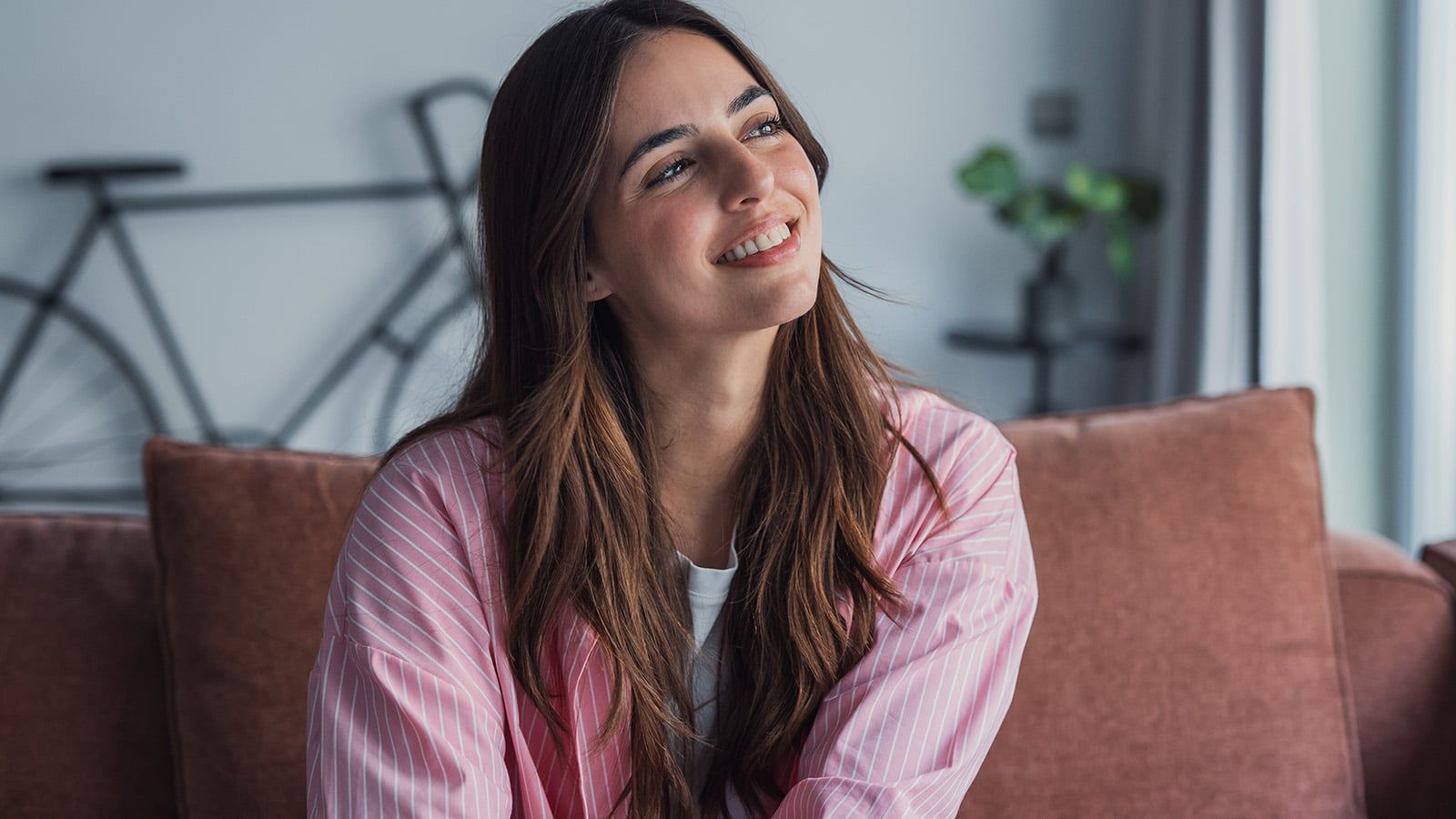 Portrait of happy dreamy young woman looking away, talking to herself