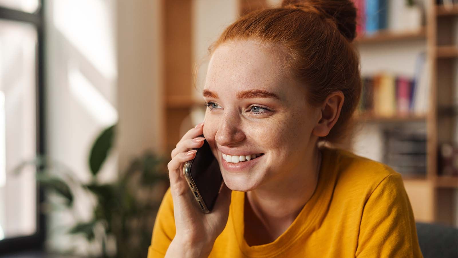 Young woman smiling talking on the phone with her parents