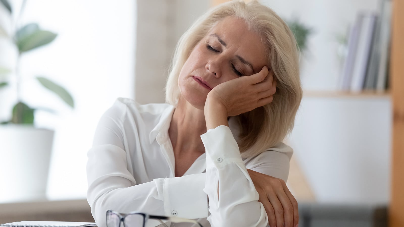 tired senior businesswoman feel fatigue sleeping at workplace taking break dreaming or visualizing