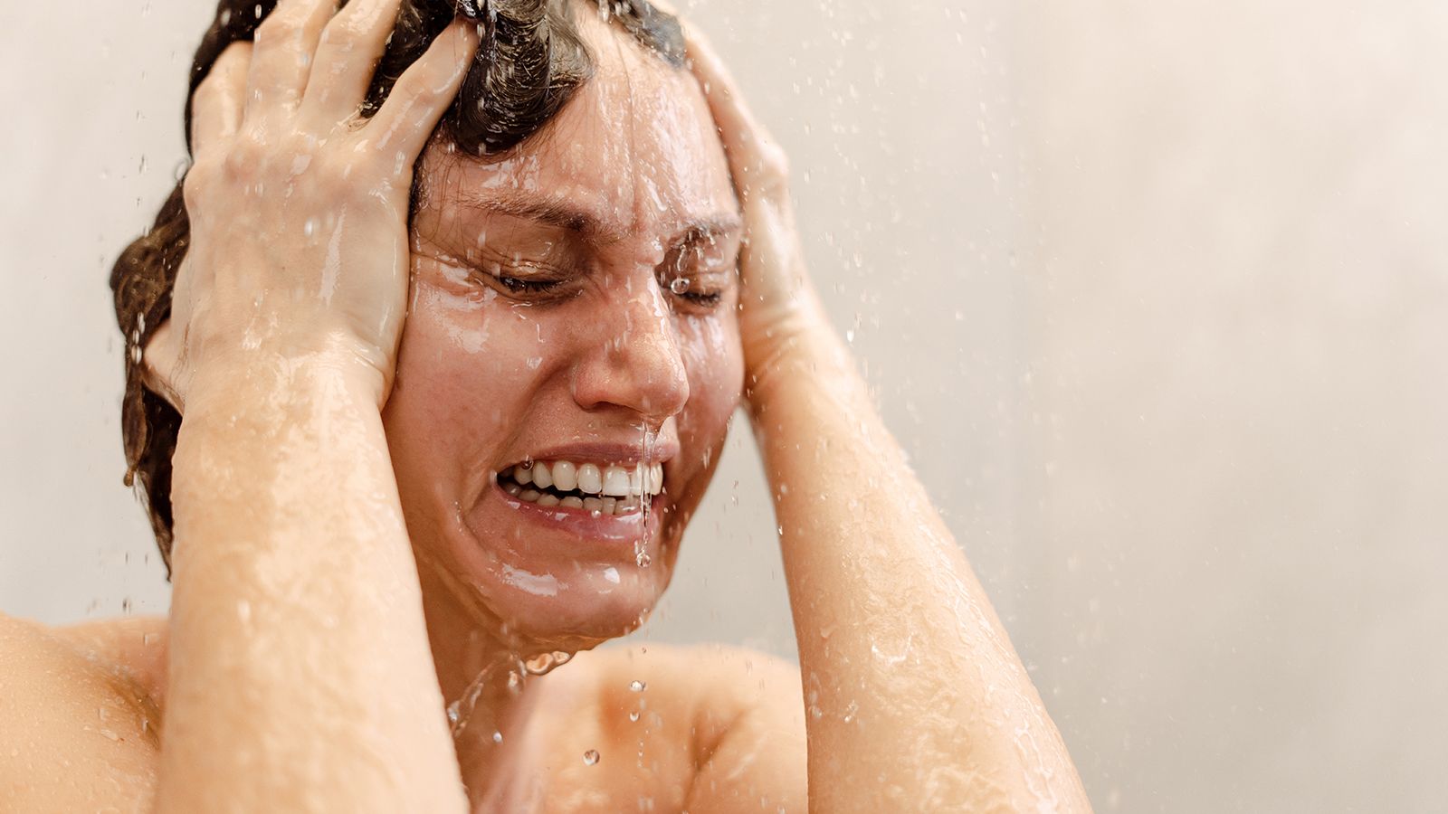 Young woman crying in the shower