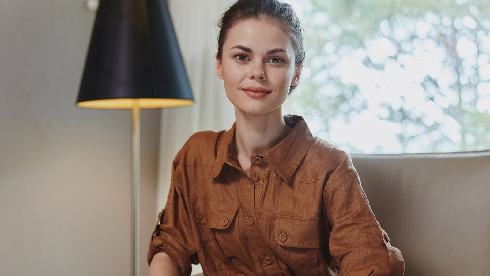 Young woman sitting in a well lit room.