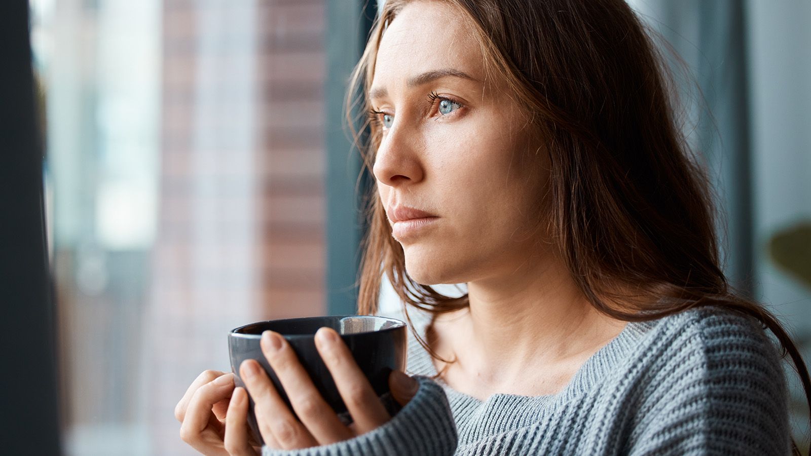 Young woman drinking her morning coffee, reflecting how something feels missing in her life.