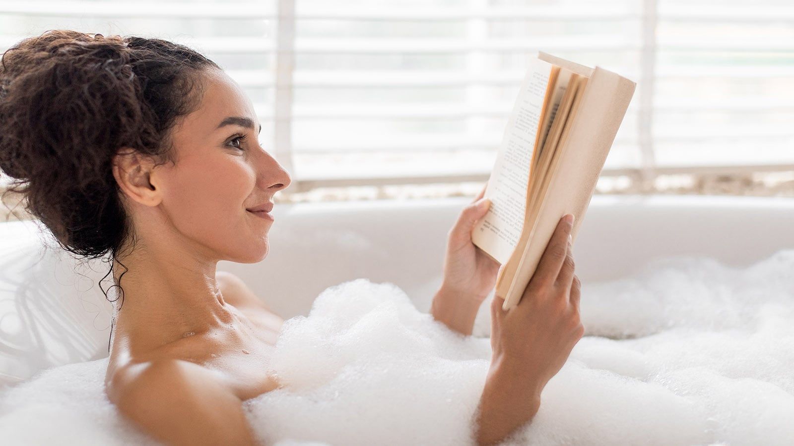 Relaxing Bath Time With a Book and Soothing Bubbles in a Cozy Space