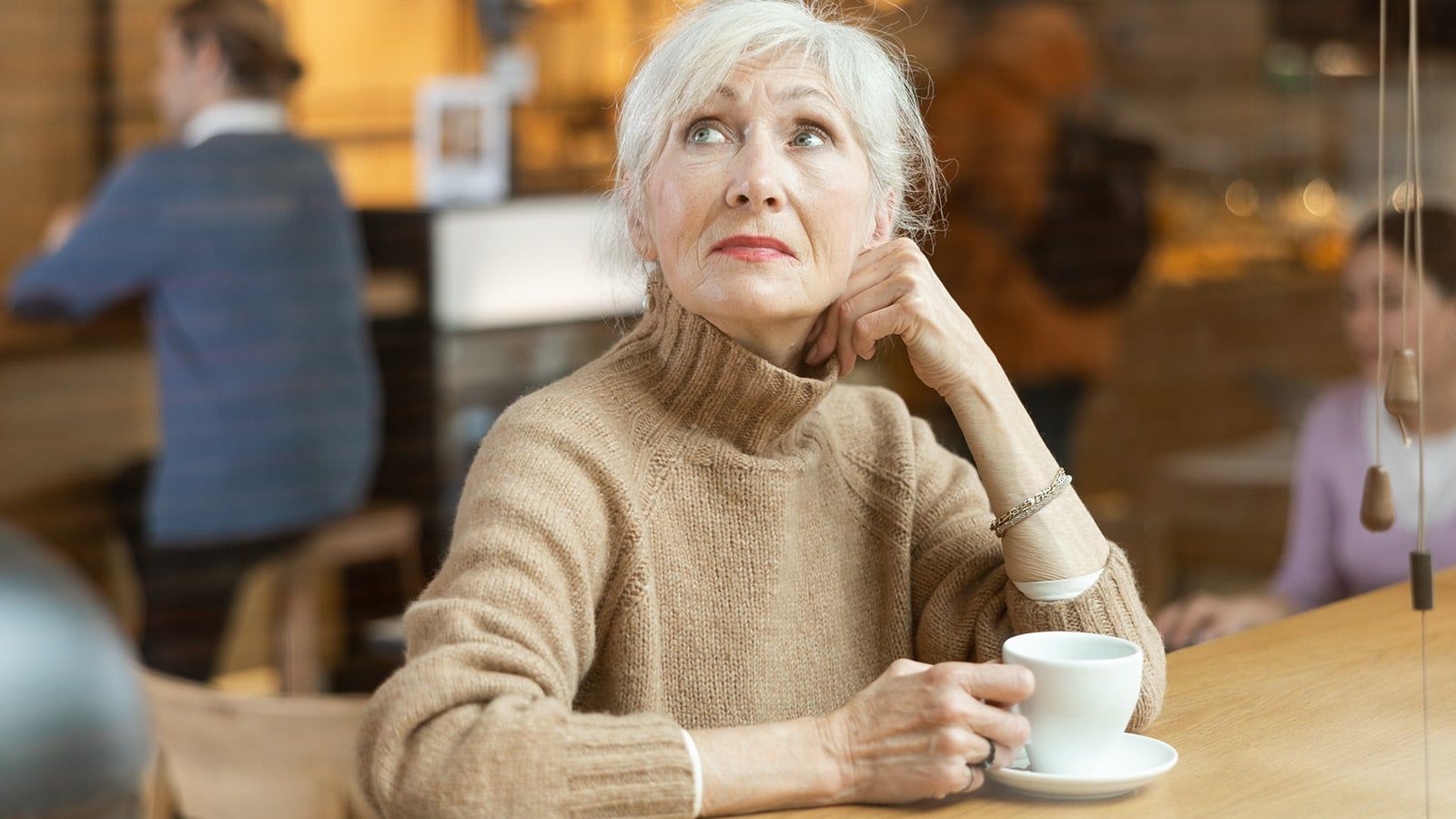 Woman in her 70s retired and thinking about life in a coffee shop