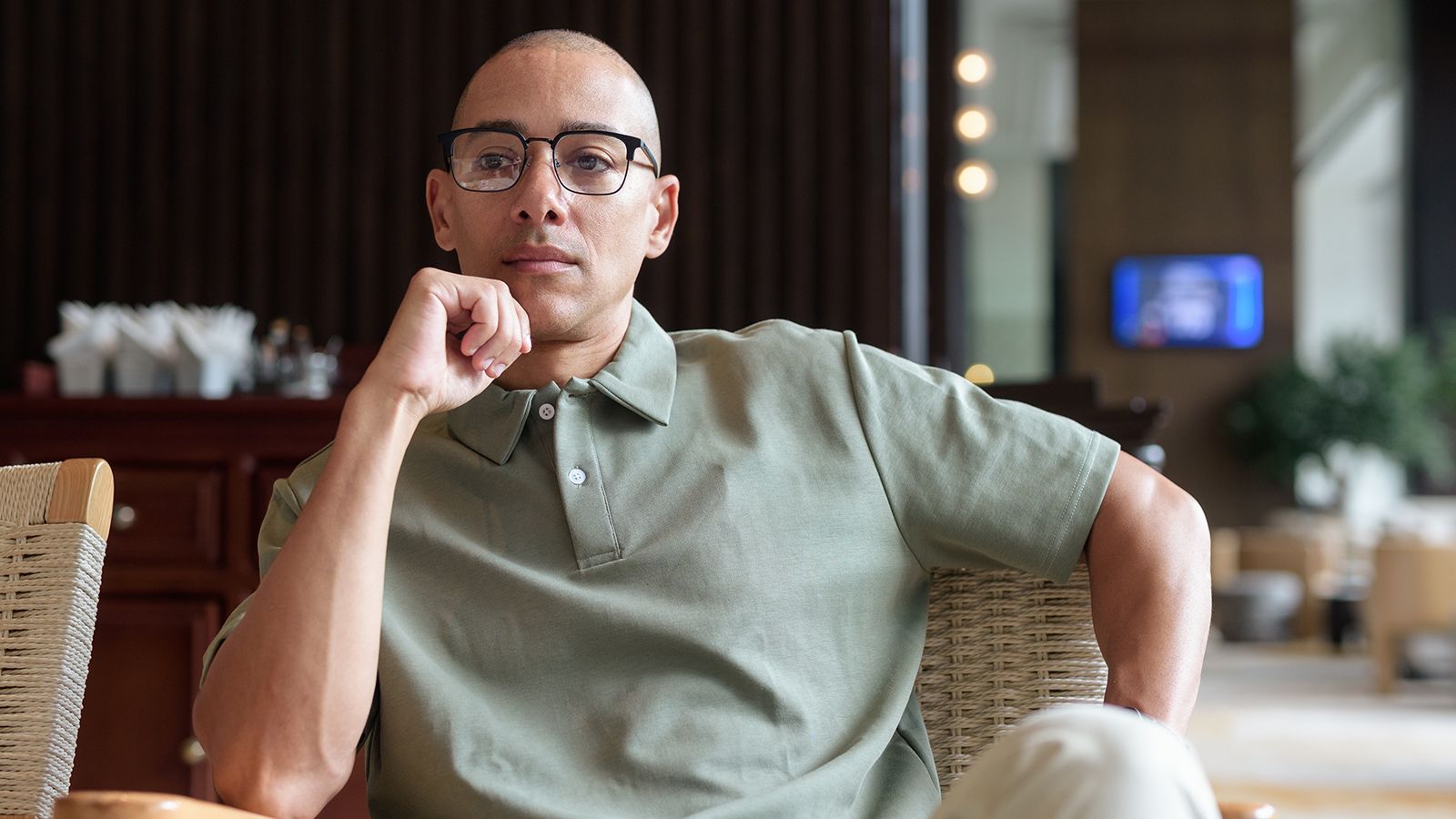 man in his 40s posing in hotel cafe or bar pondering life