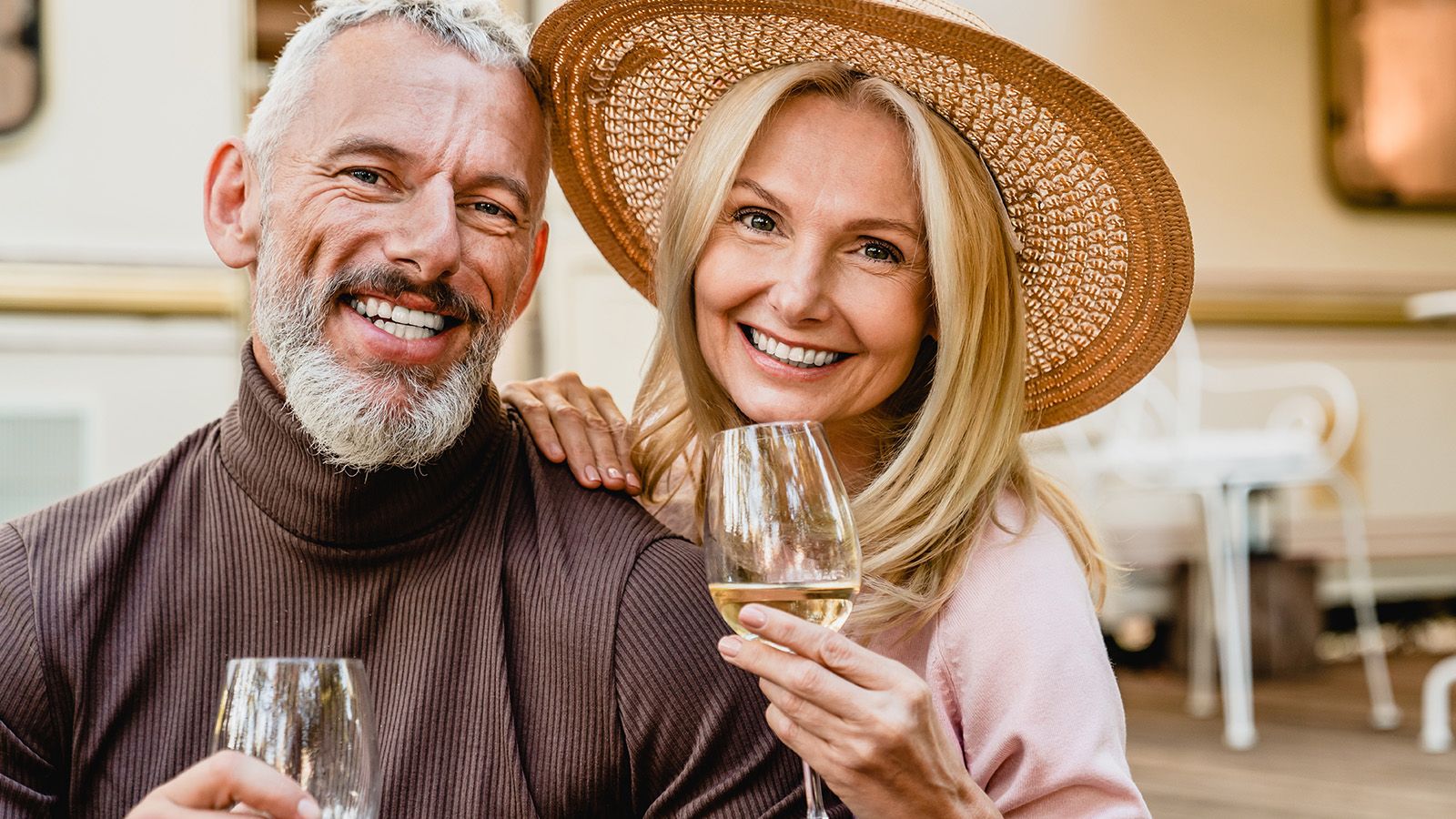 Wealthy couple drinking wine and hiding the difficulties they face behind the smiles