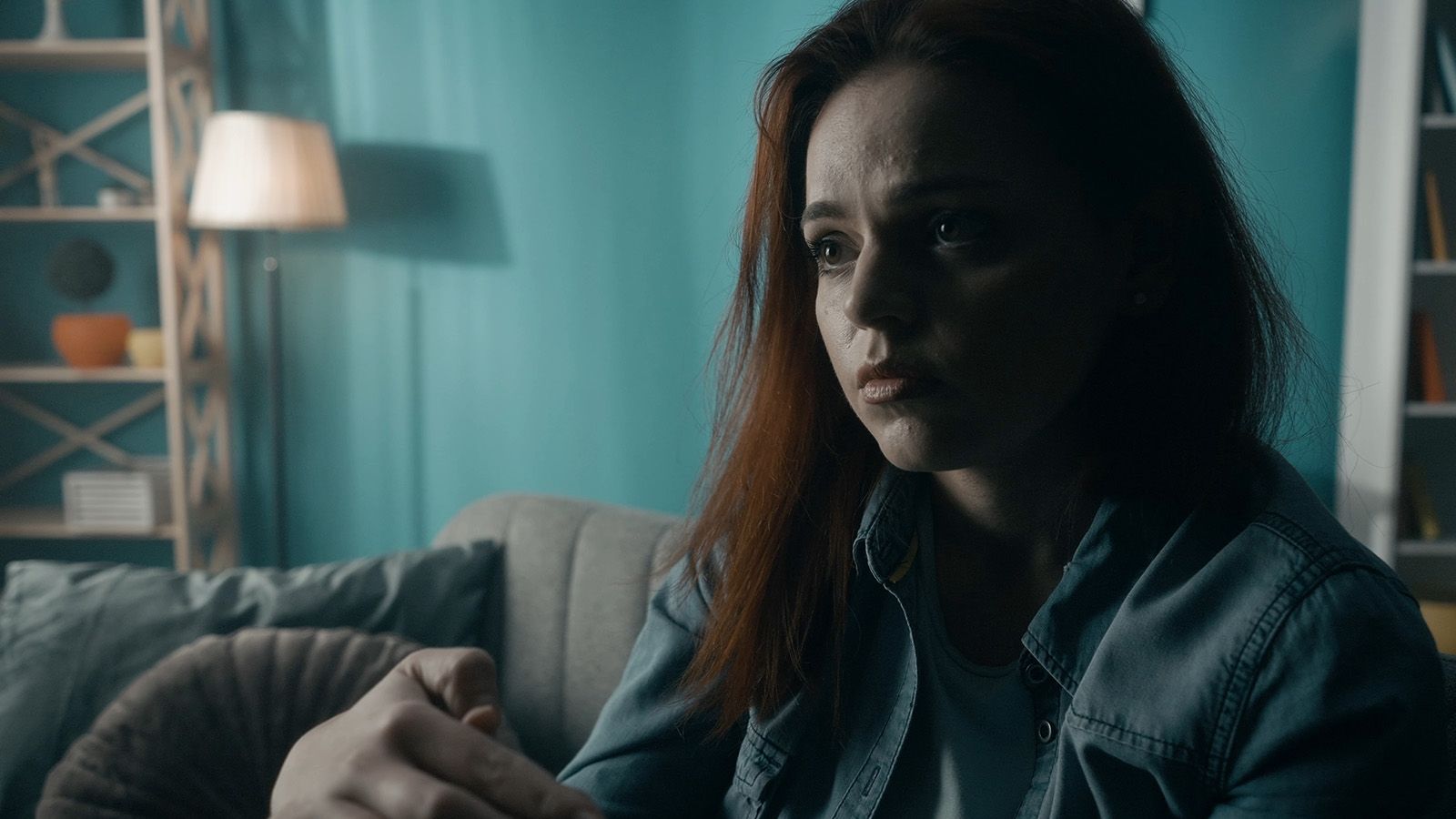 Woman sitting in a dimly lit room.