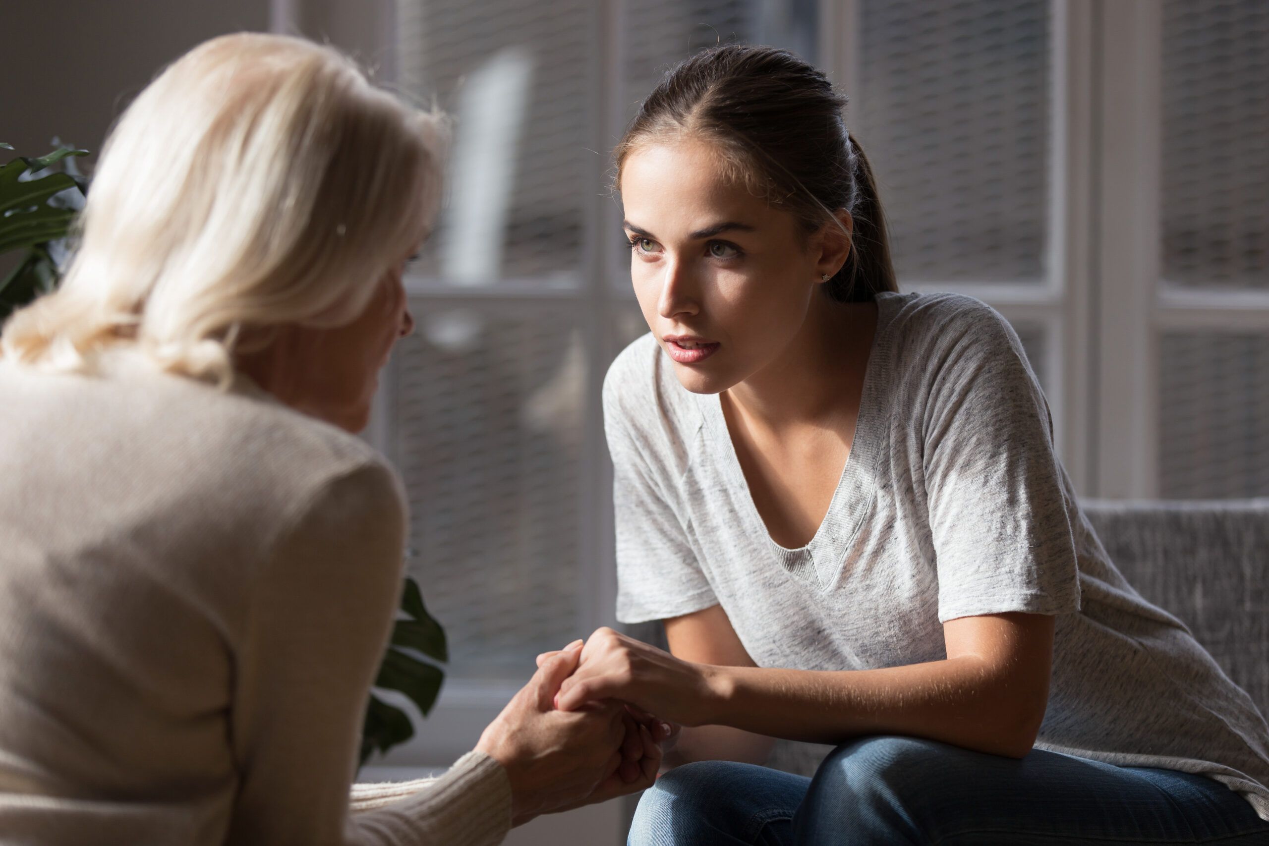 Adult daughter having a heart-to-heart conversation with her aging mother.