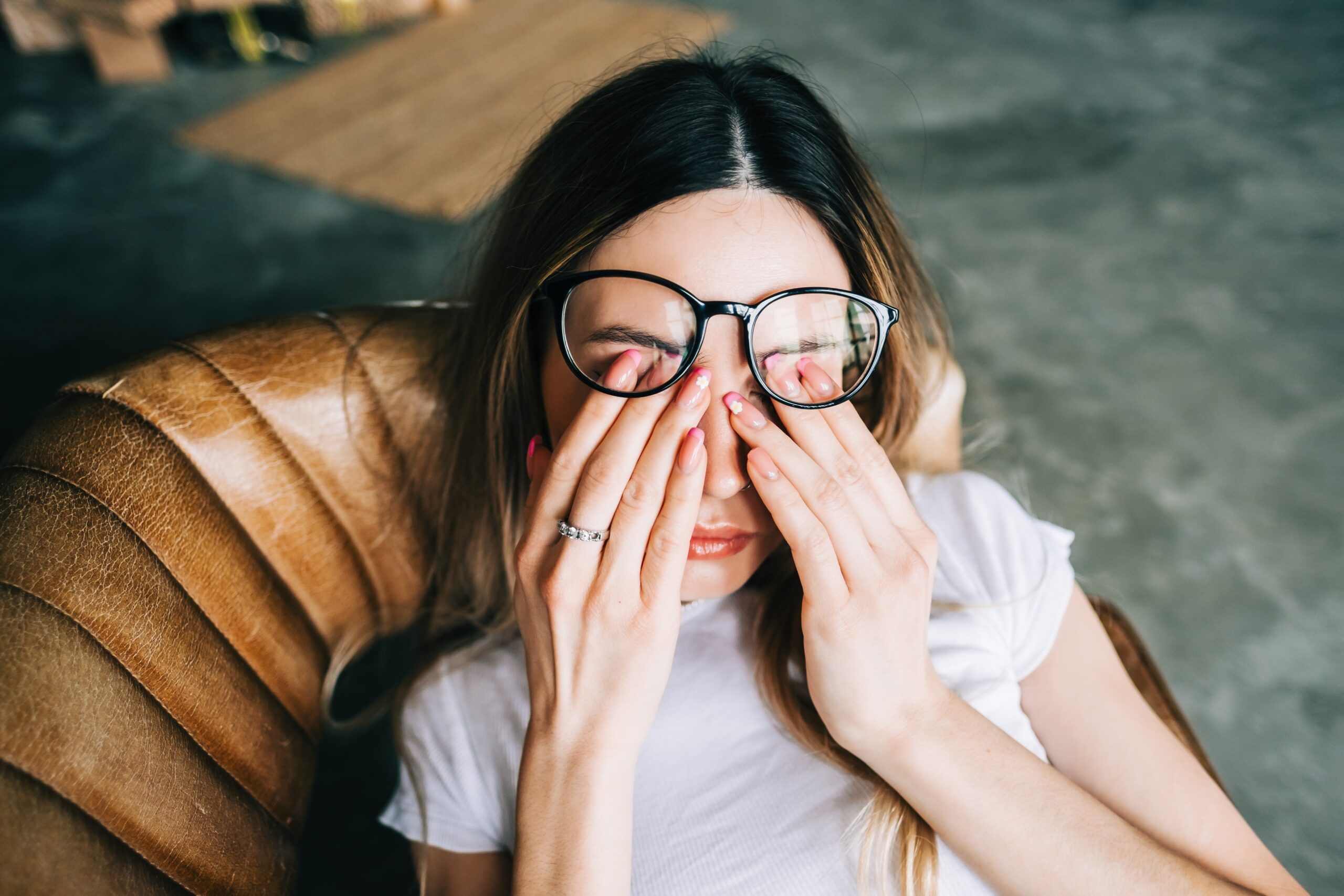 Young woman feeling burned out, rubbing her eyes in exhaustion.