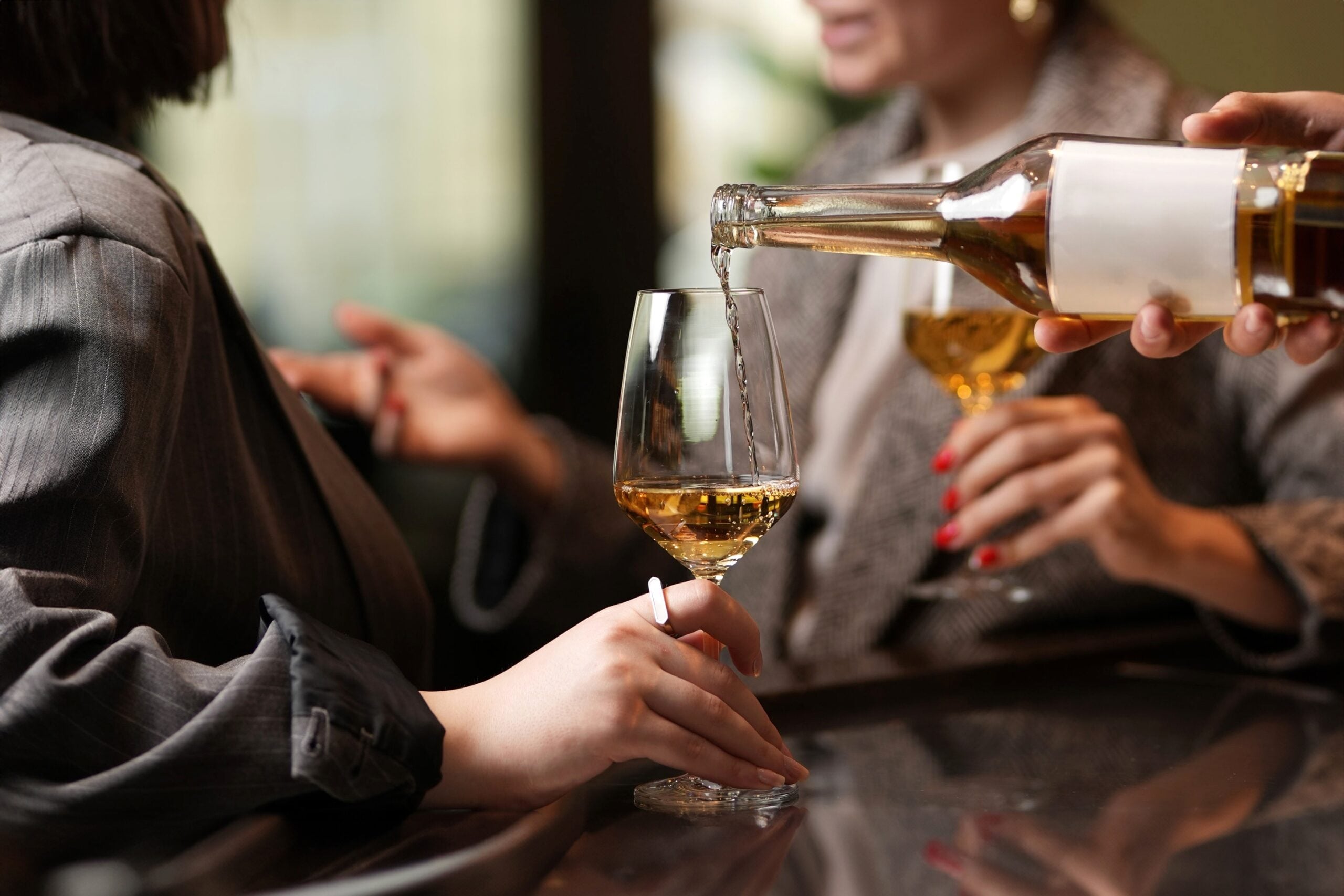 Two women talking over a glass of wine.