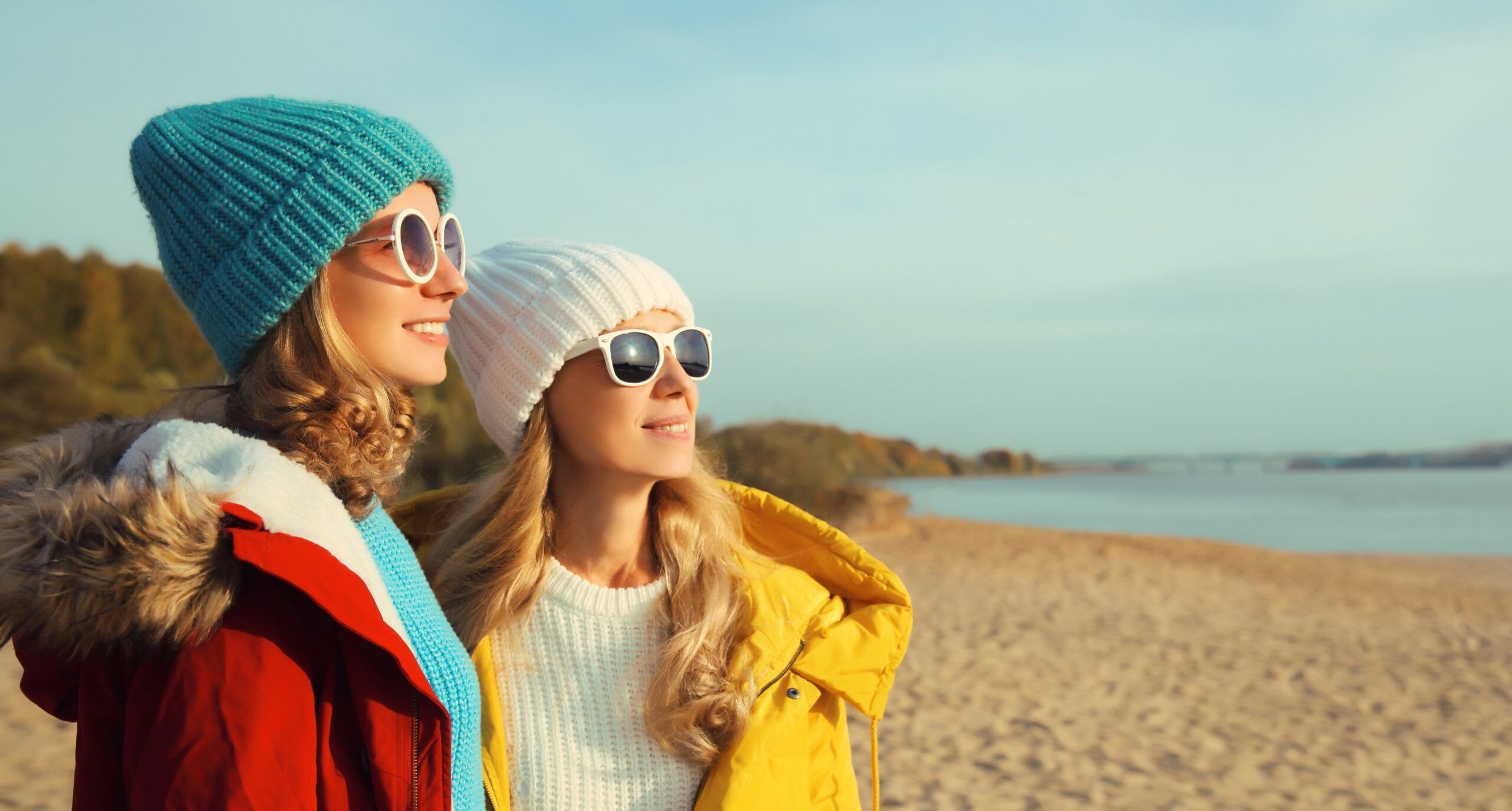 Two intelligent girlfriends on a walk by the beach.