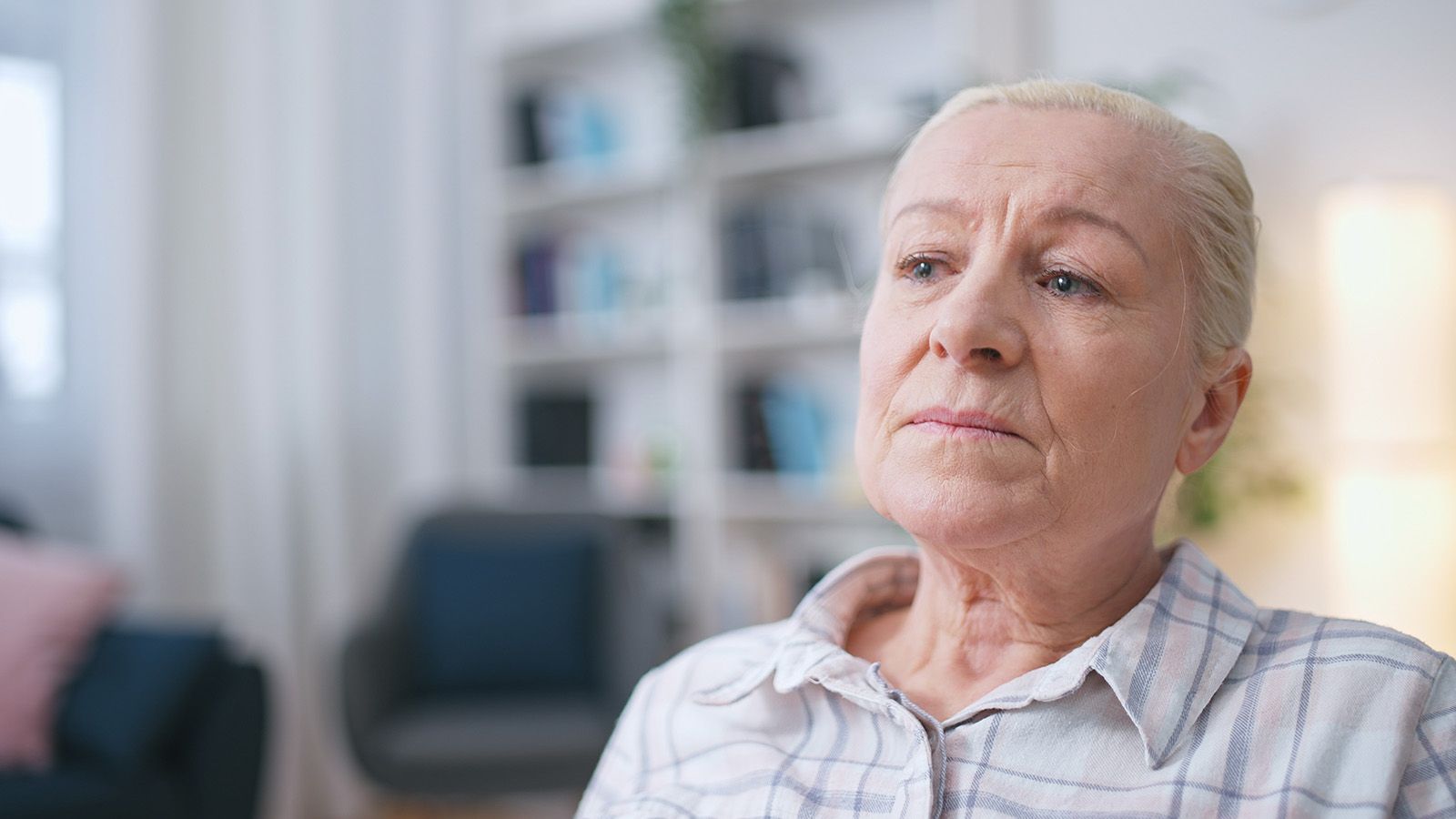 Elderly woman sitting and reflecting on her past.