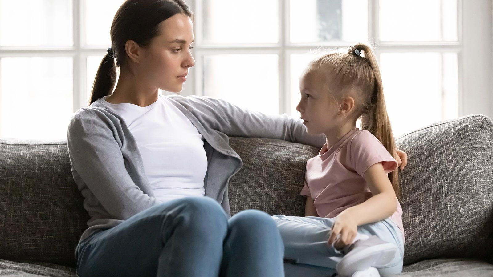 focused mother having conversation with small daughter