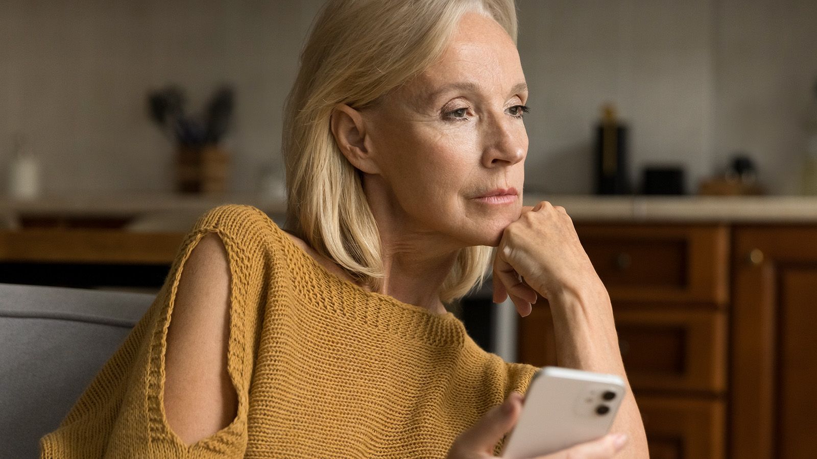 Boomer woman sad looking at smart phone