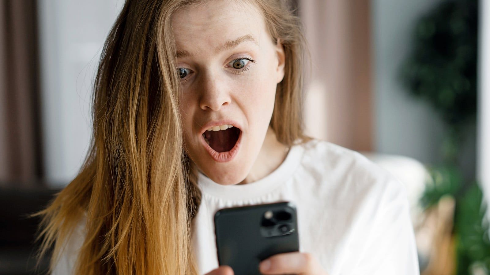 Surprised woman looking at her cell phone