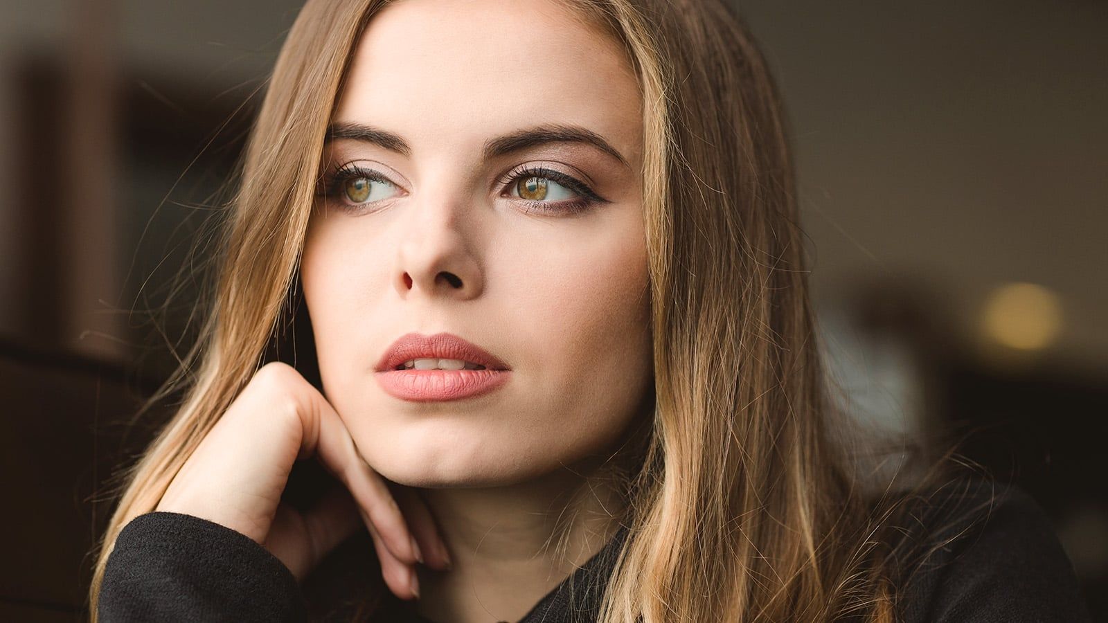 Portrait of attractive thoughtful young woman sitting at home