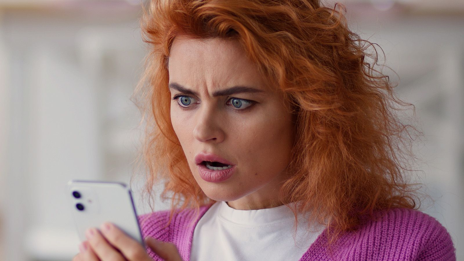 Pretty young woman shocked and disappointed looking at her phone