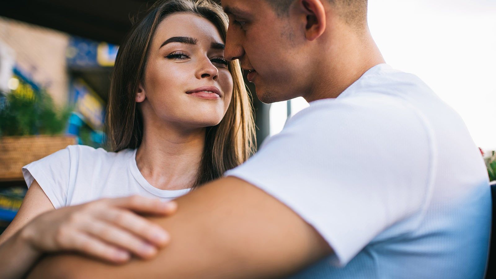 Portrait of positive female in casual wear smiling at camera while spending free day with lovely boyfriend