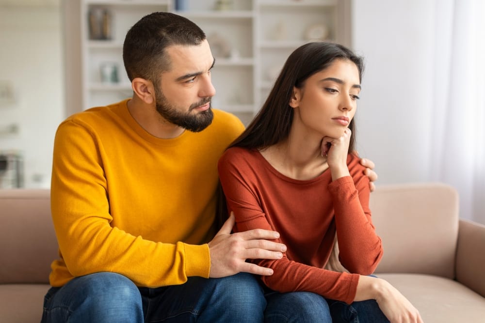 A compassionate young man showing empathy for a woman and comforting her