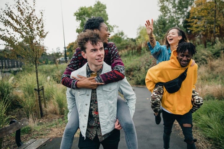 couples riding piggyback outdoors