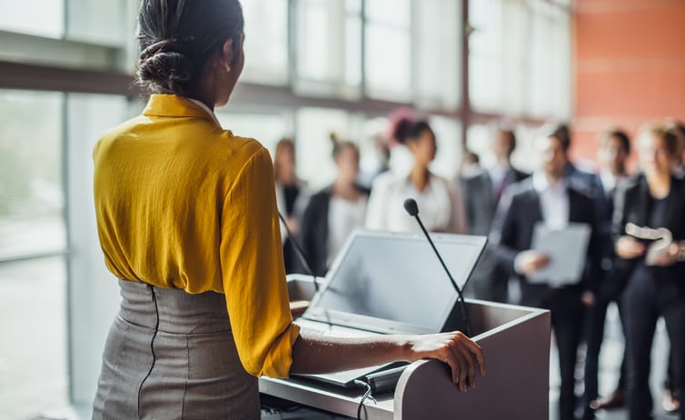 Business people at a conference listening to the speaker.