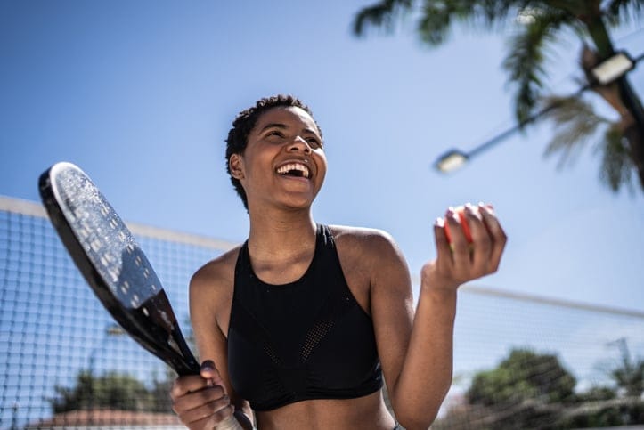 Smiling woman playing tennis.